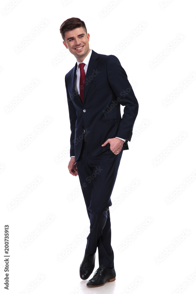 laughing businessman standing with legs crossed and hand in pocket laughing businessman standing with legs crossed and hand in pocket