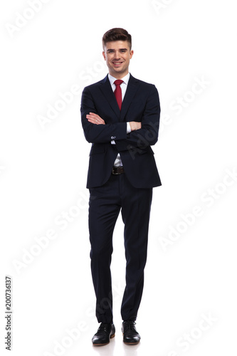 happy businessman standing with arms folded