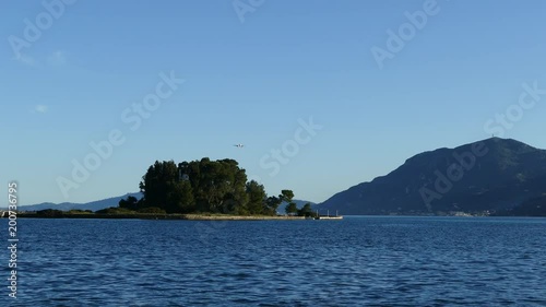 Beautiful Kanoni hill area in Corfu island with Pontikonissi island and Vlacherna Monastery. Mouse Island. Airplane landing in airport on Corfu island, Greece. photo