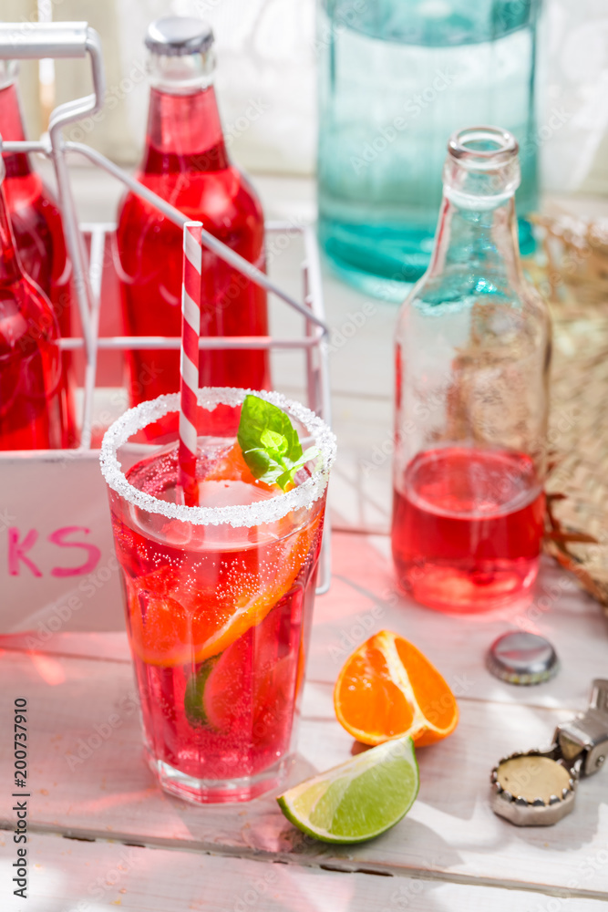Cold summer drink with citrus fruit on white table
