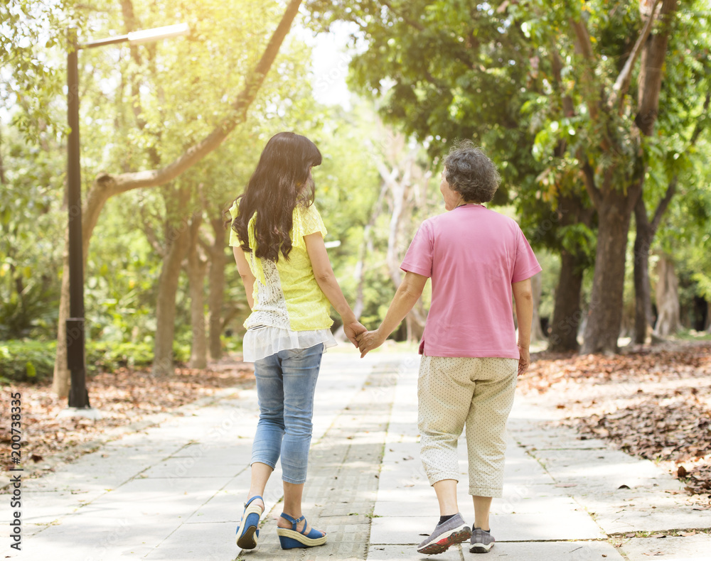 senior mother with daughter walking in the park senior mother with daughter walking in the park