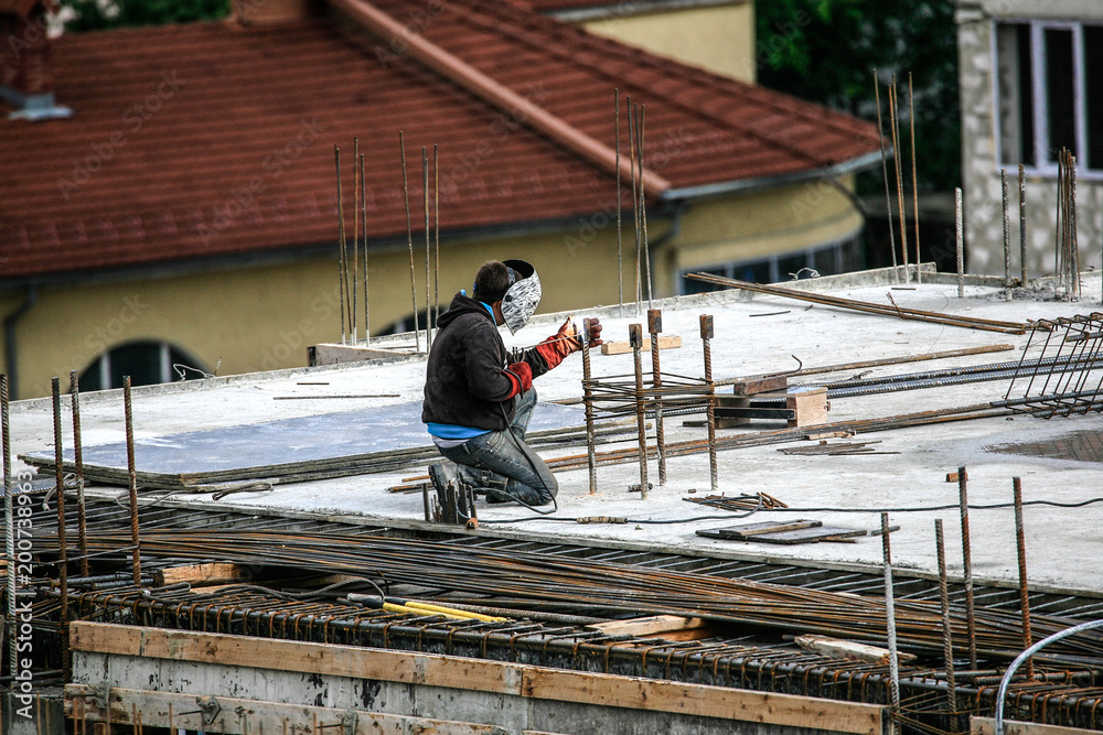 The welder welds a metal construction The welder welds a metal construction