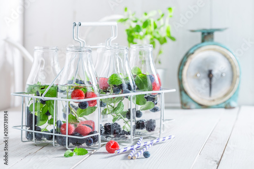 Healthy water in bottle with berries on white table