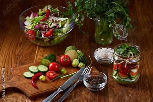 Fresh vegetable salad and ripe veggies on cutting board over wooden background  close up  selective focus