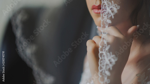 selective focus on the bride lips covored with veil photo