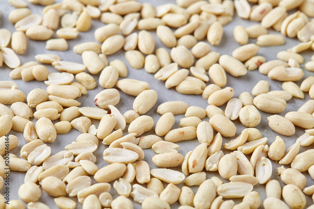 Pile of peelled peanuts isolated on white textured background, background, top view, close-up, selective focus Pile of peelled peanuts isolated on white textured background, background, top view, close-up, selective focus