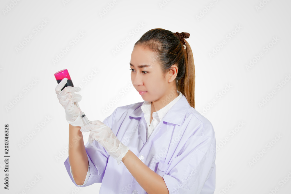 Medical gloved hand holding syringe with red blood liquid and a bead of liquid emerging testing the function of the syringe Medical gloved hand holding syringe with red blood liquid and a bead of liquid emerging testing the function of the syringe