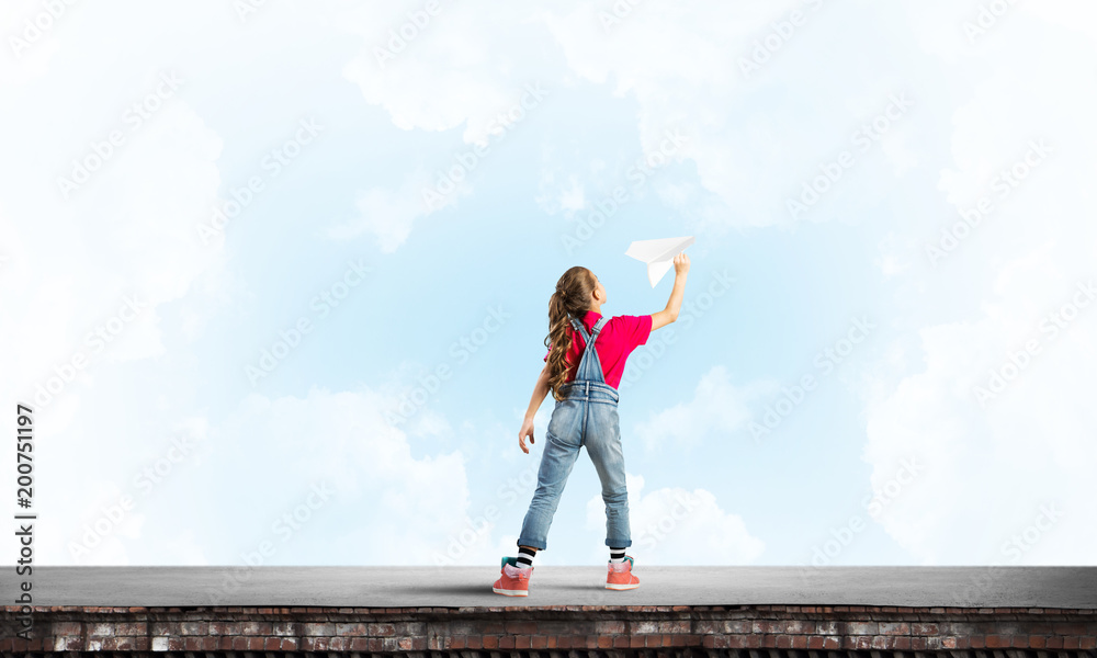 Concept of careless happy childhood with girl dreaming to become pilot Concept of careless happy childhood with girl dreaming to become pilot