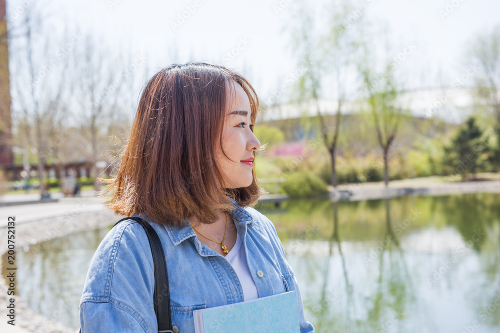 Portrait of Asian college student at campus and looking to side Portrait of Asian college student at campus and looking to side