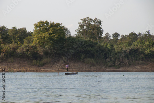 Stung Treng Cambodia, fisherman in canoe on mekong river in late afternoon