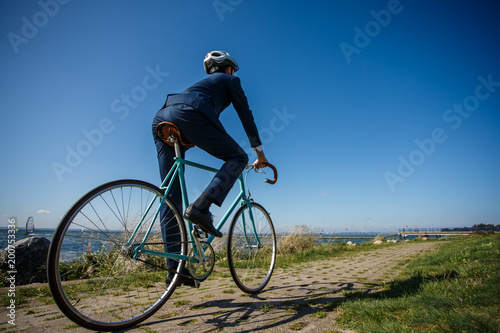 Fototapeta Naklejka Na Ścianę i Meble -  Businessman cycling at seaside