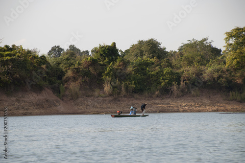 Stung Treng Cambodia, fishermen in canoe on mekong river in late afternoon