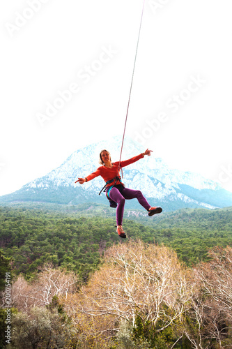 A woman is hanging on a rope.