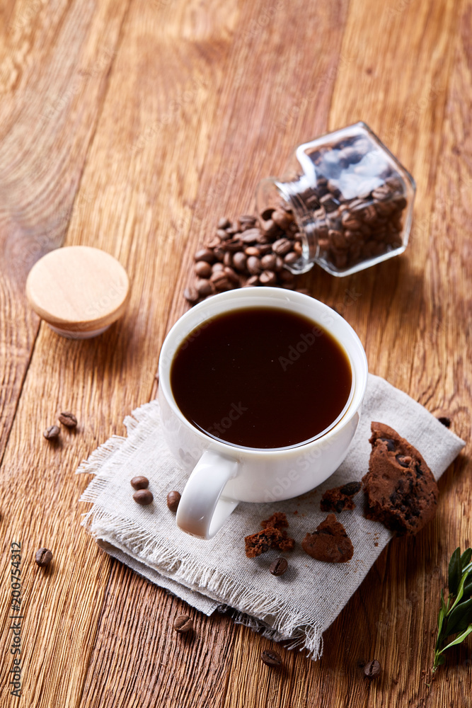 Morning coffee in white cup, chocolate chips cookies on homespun napkin, close-up, selective focus Morning coffee in white cup, chocolate chips cookies on homespun napkin, close-up, selective focus