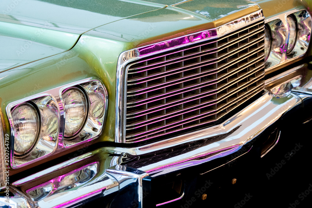 Exhibition of retro cars. Fragment of the front part of the car with round headlights and grille