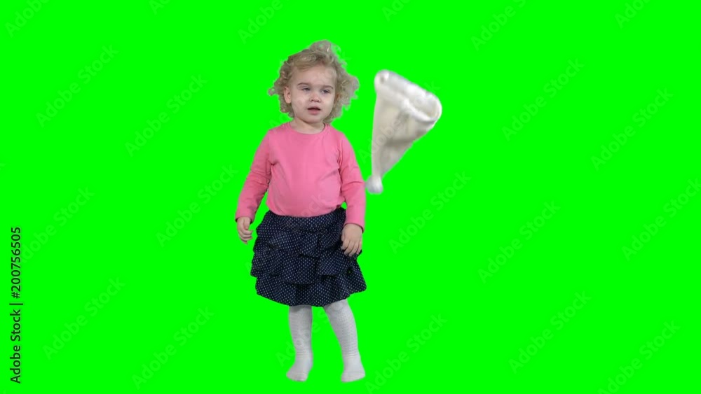 crazy little girl take off santa hat and throw away isolated on green crazy little girl take off santa hat and throw away isolated on green