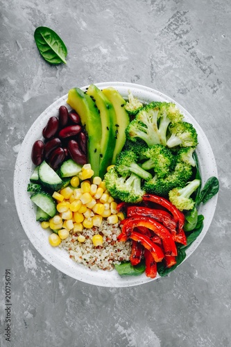 Healthy buddha bowl salad with grilled vegetables. Quinoa, spinach, avocado, beans, sweet corn, broccoli, cucumbers and paprika