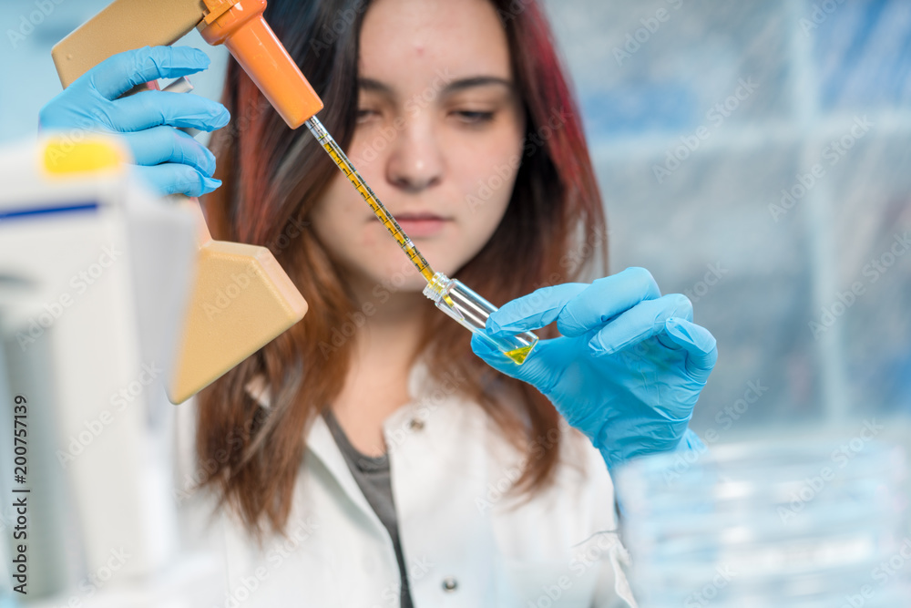 pretty female laboratory assistant analyzing a biological sample at hospital pretty female laboratory assistant analyzing a biological sample at hospital