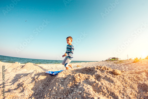 The boy walks along the sandy beach. © zhukovvvlad
