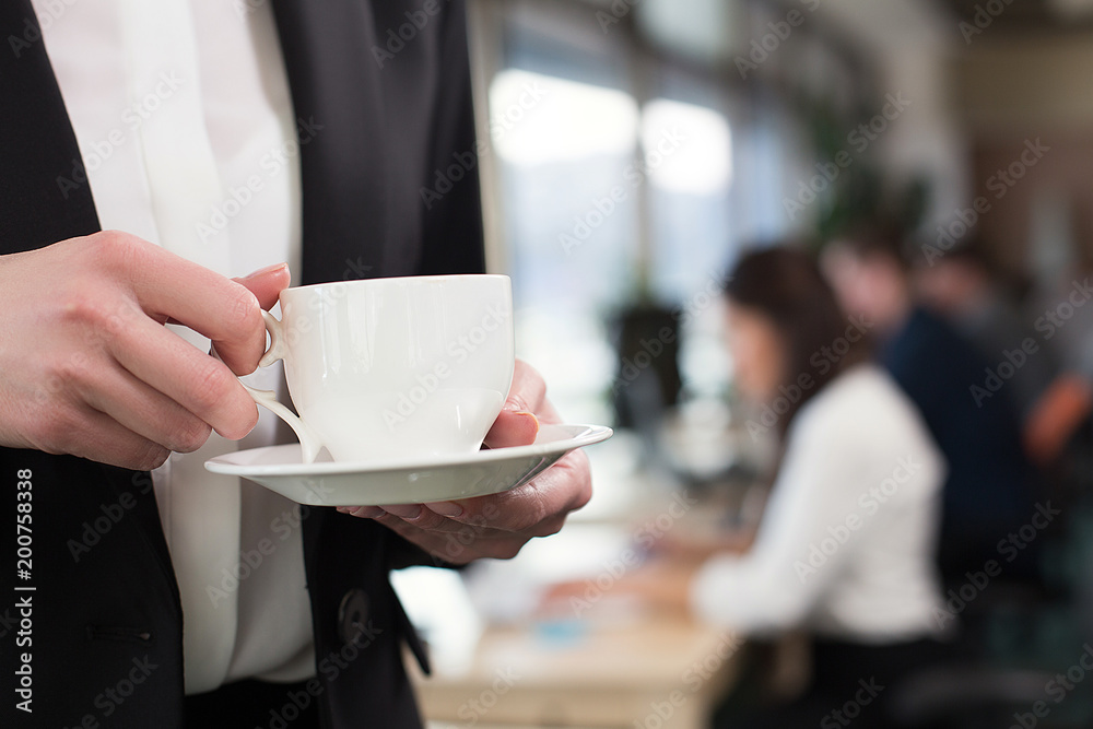 Side view image of woman hands with cup of aroma coffee in office.