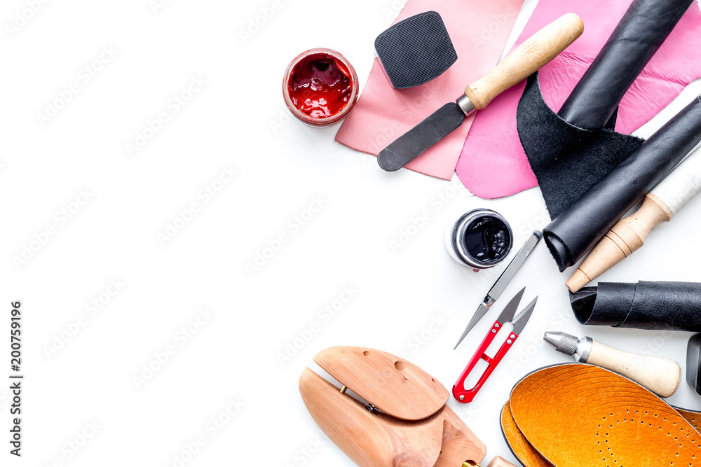 Work desk of shoemaker with instruments, wooden shoe and leather. White background top view copy space Work desk of shoemaker with instruments, wooden shoe and leather. White background top view copy space