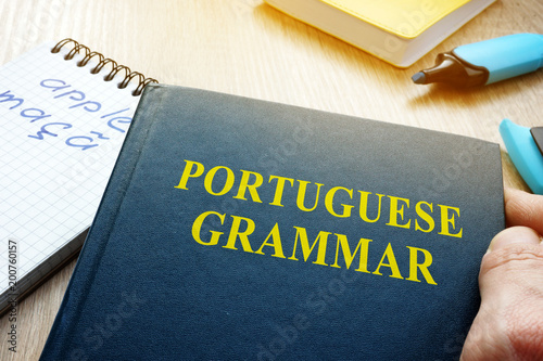 Learn portuguese grammar. Hand is holding book.