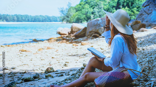 Asian woman travel nature. Travel relax. Study read a book. Nature Education Write a note. On the beach. In the summer. Thailand