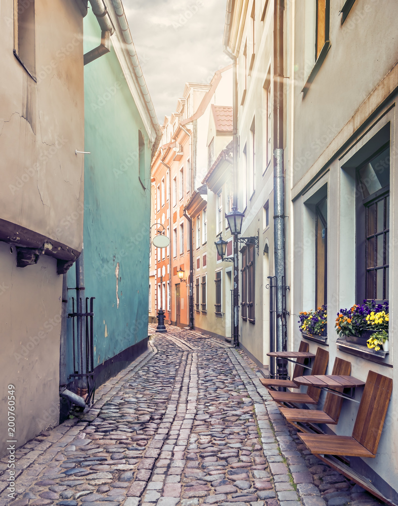 Narrow medieval street in medieval part of Riga city, where numerous tourists can find a unique atmosphere of Middle Ages and famous ensembles of Gothic architecture