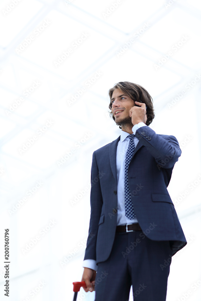 bottom view.businessman with Luggage talking on a cell bottom view.businessman with Luggage talking on a cell