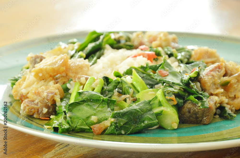 stir fried Chinese kale and crispy pork with chili on rice stir fried Chinese kale and crispy pork with chili on rice