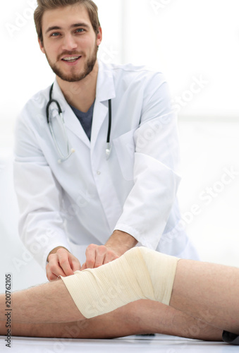 doctor looking at the bandage on the patient's leg
