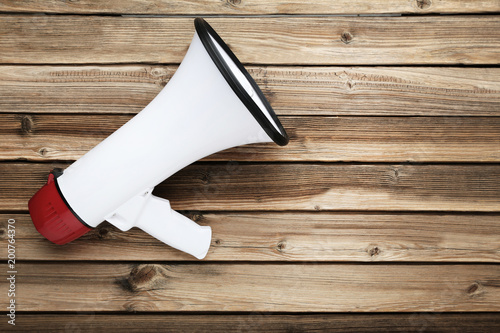 White megaphone on brown wooden table