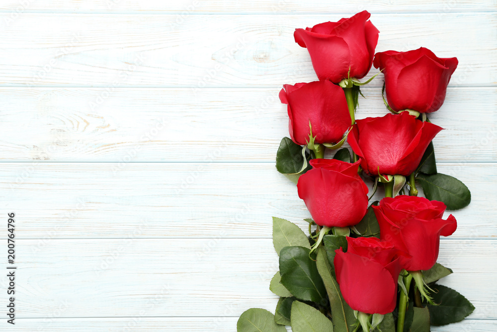 Fototapeta premium Bouquet of red roses on white wooden table