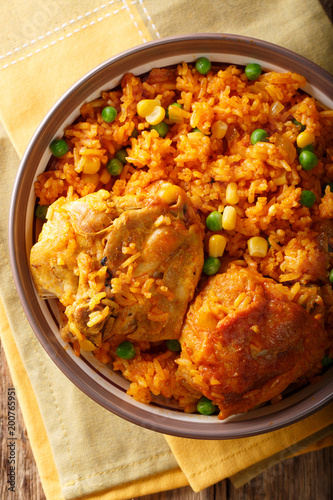 Galinhada is the Brazilian version of arroz con pollo chicken and rice close-up on a plate.Vertical top view