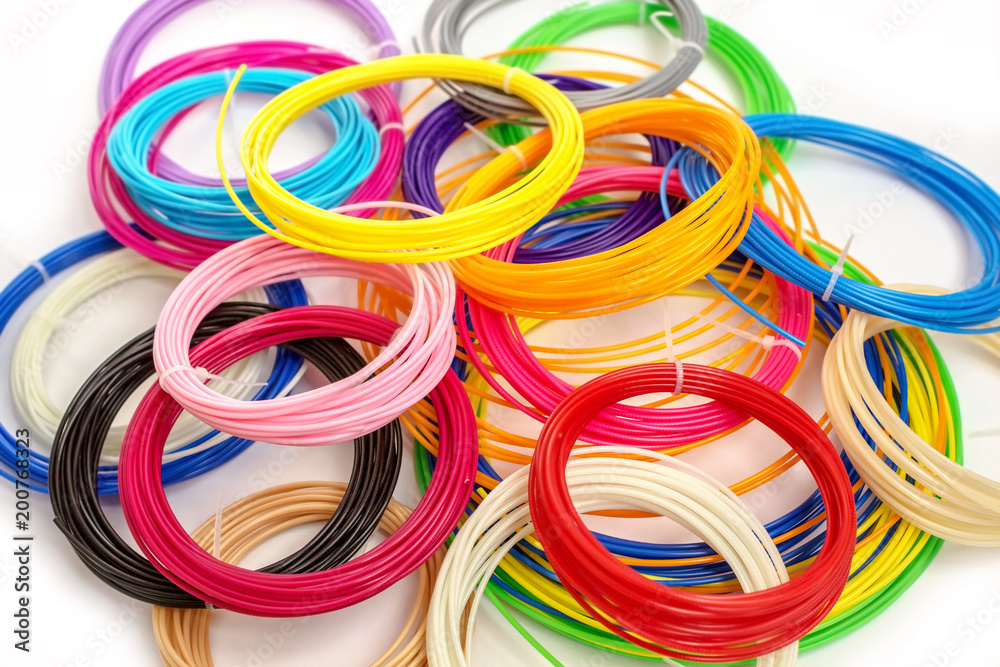 Pile of colourful ABS plastic filament for 3D printer and pen on white background. Pile of colourful ABS plastic filament for 3D printer and pen on white background.