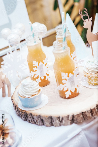 cupcake and bottles with juice stand on a tray of wood