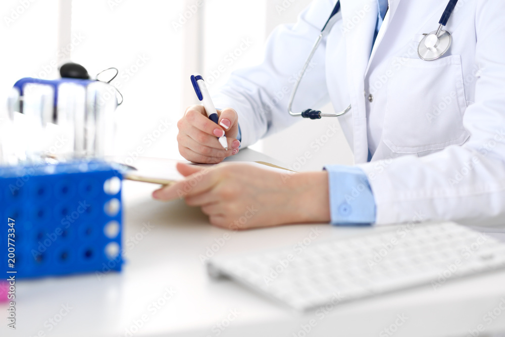 Female doctor filling up medical form on clipboard closeup. Physician finishing up examining his patient in hospital and ready to give a prescription to help. Healthcare, insurance and medicin Female doctor filling up medical form on clipboard closeup. Physician finishing up examining his patient in hospital and ready to give a prescription to help. Healthcare, insurance and medicin