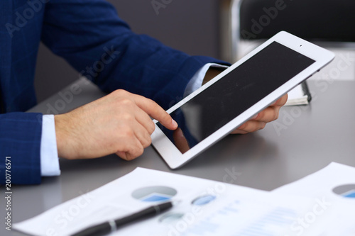 Businessman using touchpad at meeting, closeup of hands