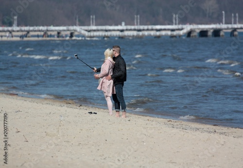 Młoda para robi selfie na plaży przy użyciu selfiestick 