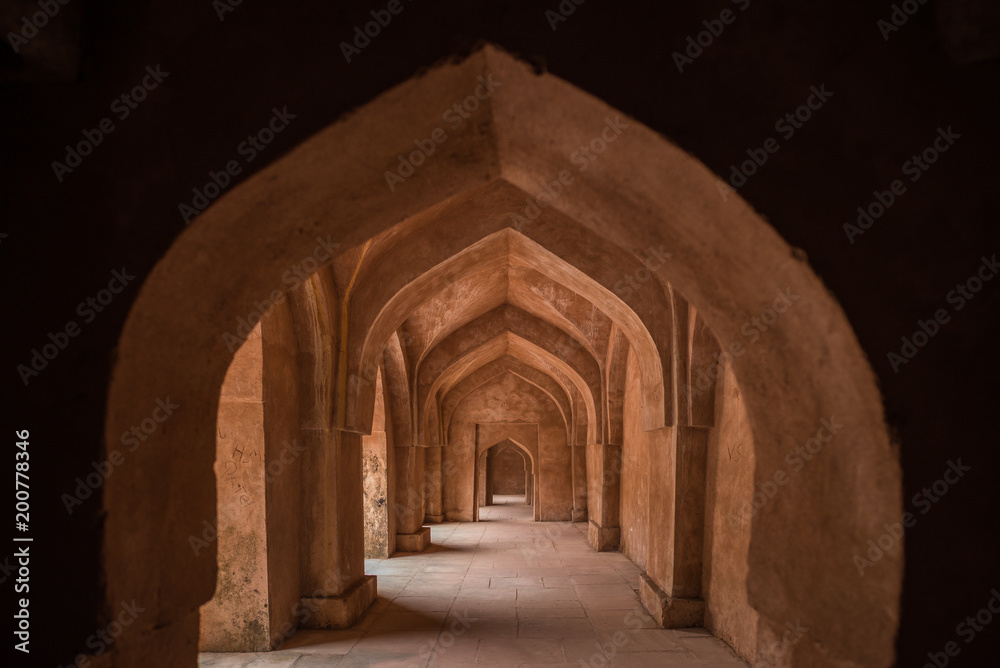 Mandu India, afghan ruins of islam kingdom, palace interior, mosque monument and muslim tomb. Sunshine from door in dark corridor. Mandu India, afghan ruins of islam kingdom, palace interior, mosque monument and muslim tomb. Sunshine from door in dark corridor.