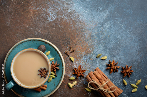 Indian masala chai tea. Spiced tea with milk on dark rusty background. Top view, flat lay, copy space.