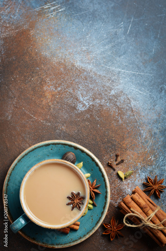 Indian masala chai tea. Spiced tea with milk on dark rusty background. Top view, flat lay, copy space.