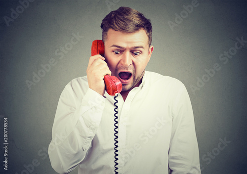Shocked man having news on phone