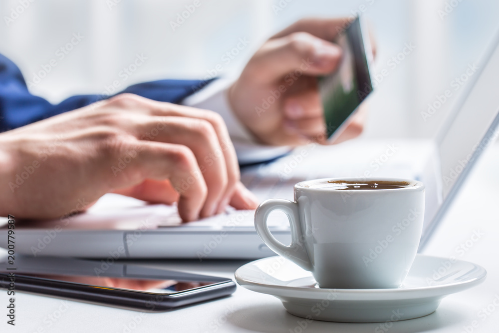 Man hands typing on the keyboard of laptop holding credit card, close-up of online shopping Man hands typing on the keyboard of laptop holding credit card, close-up of online shopping