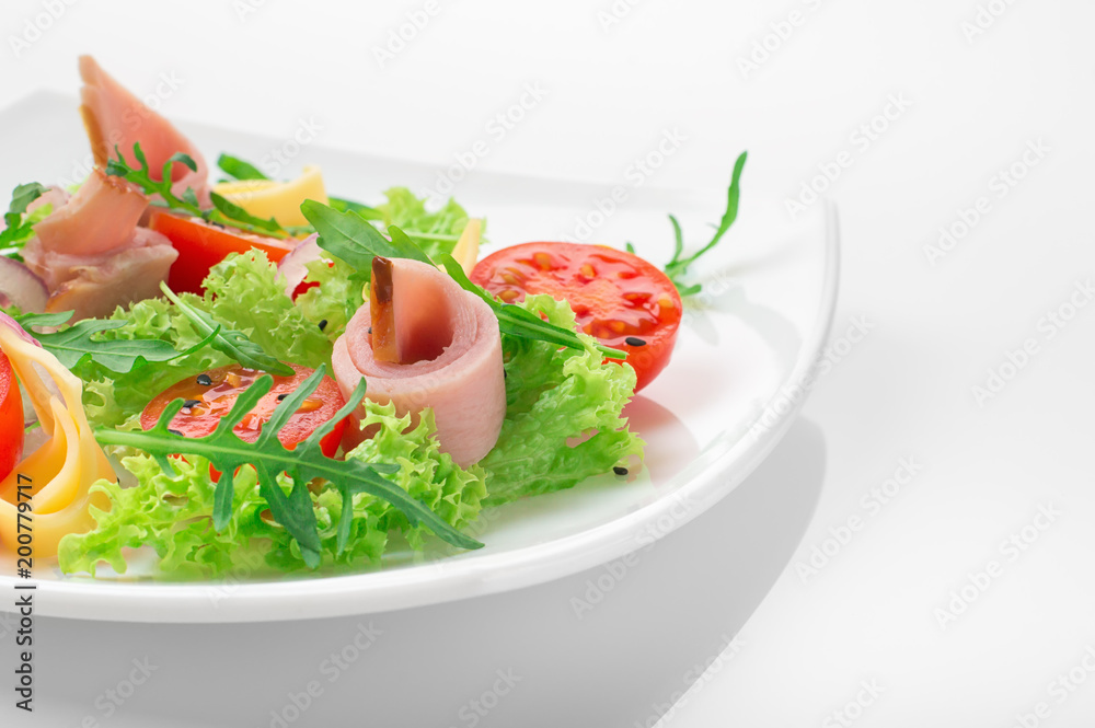 Fresh salad with tomatoes, arugula, cheese and ham on the white plate and white background Fresh salad with tomatoes, arugula, cheese and ham on the white plate and white background