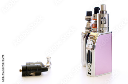 E-cigarettes and atomizers over white table surface. Vaping background still life photography. Background for shops or vapor enthusiast. photo