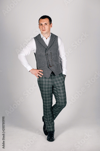 stylish man in checkered suit on a gray background