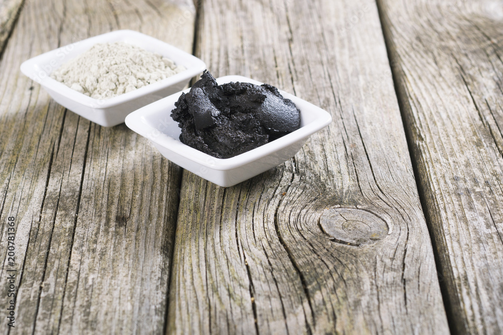 gray cosmetic clay powder and black mud on old wood texture gray cosmetic clay powder and black mud on old wood texture