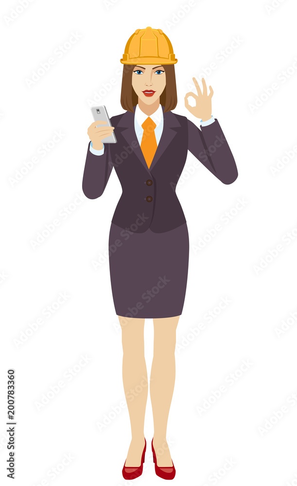 Businesswoman in construction helmet using a mobile phone and  show a okay hand sign