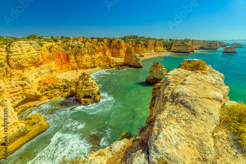 Aerial view of high cliff of Praia da Marinha in Algarve, Portugal, Europe. Scenic landscape of Marinha Beach, one of the 10 most beautiful beaches in Portugal. Sunny day in turquoise waters.